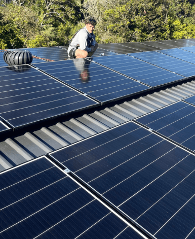 solar technician on roof with solar panels